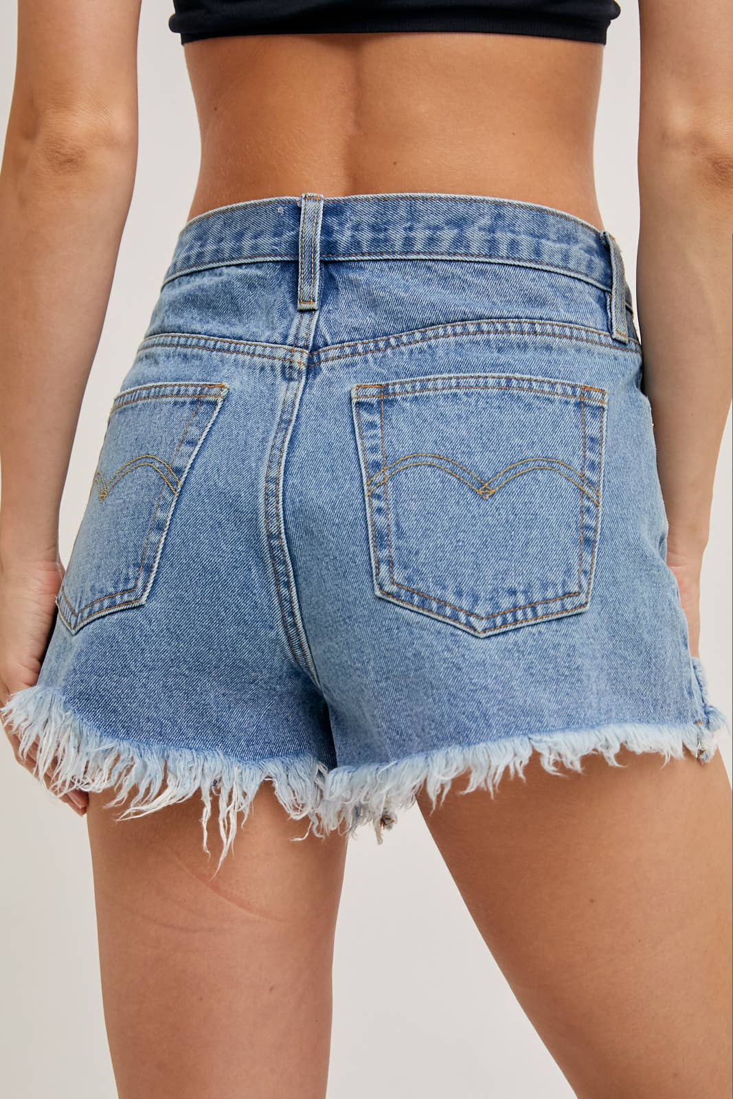 DISTRESSED MID-RISE DENIM SHORTS